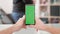 Man s point of view holding a smartphone vertically with green screen on in the center of the frame