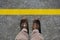 Man`s shoes view from above and a yellow limit line with copy space for your text