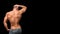 Man`s strong fitness back isolated on dark background