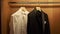 Man`s suit hangs in the closet and is illuminated.Men`s suit at tailor`s shop. Men`s hands choose a jacket in their wardrobe.