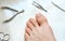 Man`s toenails with manicure tools. Foot and toes close-up. Top view.