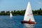 Man on sailing boat and windsurfer