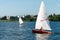 Man on sailing boat and windsurfer