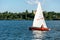 Man on sailing boat and windsurfer