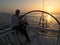 Man sailing sitting yacht deck sunset evening steering wheel