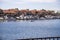 A man sailing a small motor boat at Huntington Harbour with boats and yachts docked in Huntington Harbour and homes