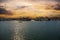 A man sailing a small motor boat at Huntington Harbour with boats and yachts docked in Huntington Harbour and homes