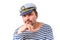 A man sailor in a cap with a smoking pipe in front of a white ba