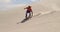 Man sand boarding on the slope in desert 4k