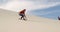 Man sand boarding on the slope in desert 4k