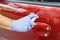 Man sanitizing door handle of his car outdoors.  Male hand in protective glove holding sanitizer closeup