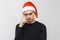 Man in santa hat, thinking about holidays. Serious face and look