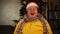 Man in Santa hat and tinsel sitting with shocked and surprised emotion