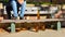 man sat on a bench with many big orange bottles of beer made of glass completely empty at the park due to somebody has drunk time