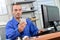 Man sat in front computer holding electrical component