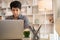 Man sat typing away on a laptop in his office with a determined look on his face