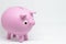 Man saving money in ceramic piggy bank or mud with pink piggy shape