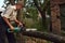 A man is sawing a tree branch.