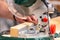 Man sawing wood with a circular saw on a workbench clouse up