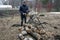 A man saws a birch log on a special stand with an electric saw. Harvesting firewood