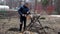 A man saws a birch log on a special stand with an electric saw. Harvesting firewood