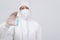 Man scientist wearing biological protective uniform suit clothing, mask, gloves with hand sanitizer dispenser for sanitizing virus