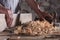 Man scraping curled wood scraps with hand plane tool