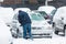 Man scraping frozen snow from the car windows