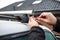 Man with a screwdriver installs attachments for trunk or cargo box on roof of the car