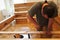 A man screwing screws in a wooden beams in assembling a new bed as improvement of his home.