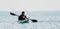 Man sea kayak. Happy free man in kayak on ocean, paddling with carbon paddle. Calm sea water and horizon in background