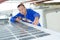 Man sealing around solar panel on roof vehicle