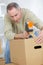 Man sealing cardboard box with brown tape