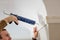 Man seals crown moulding with caulk gun