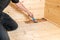 A man seals a wooden floor with a glaze and a brush