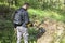 Man searches the slope in the forest in search of treasure using a metal detector.