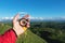 Man searching direction with a compass in his hand in the summer mountains point of view. Direction Search