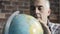 Man searching for a place on a globe