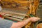 A man seated at a wooden handloom