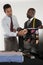 Man selecting neckwear while shop owner standing besides him