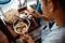 man seller put chicken topping over noodles in a bowl