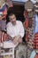 Man sells colorful knit scarfs and hats in Chefchaouen, Morocco.