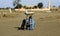 Man sells sweets and protects herself from the midday heat by si