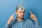 Man with a serious face shows a finger at a cap with aluminum foil. Protects from reading think