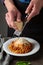 Man serving spaghetti with cheese, italian food
