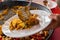 Of a Man serving typical paella from Valencia (Spain) on white plates in a restaurant