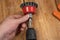 Man set up knot cup wire brush in cam of an electric drill chuck. Tool for woodworking, sanding, removing rust from various