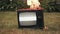 Man sets fire to an old retro TV by throwing a burning rag at it