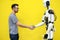 A man shakes hands with a robot close-up. engineer to create a robot. future robotics concept