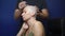 Man shaves a bald woman with an electric razor on a blue background. chemotherapy effects concept.